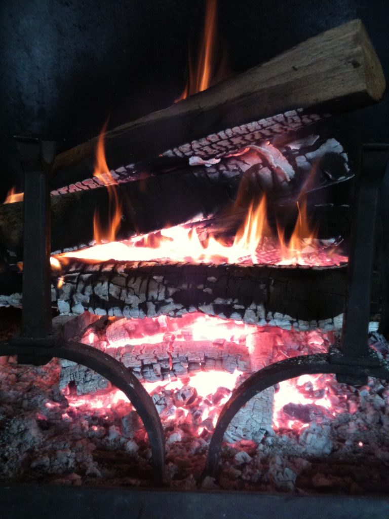 Ambiance chalet du Gran Maci Manigod : Feu et braises pour réchauffer le salon avec une cheminée en pierre d'origine